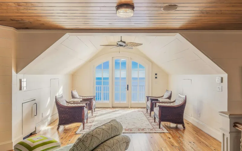 Bright and luxurious loft overlooking the ocean, featuring modern furniture and design.